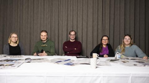 Journalismin tutkijoita istumassa pöydän ääressä. 