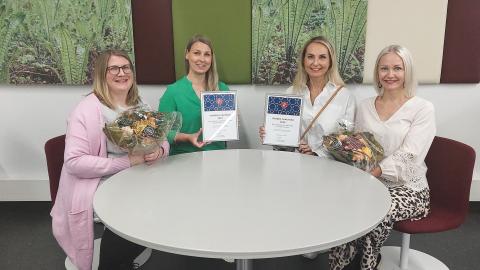 Vuoden lukuteko -palkittuja istumassa pöydän ääressä. 