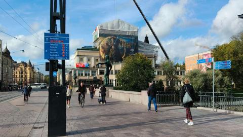 Pyöräopaste Hämeensillan valopylväässä, kävelijöitä ja pyöräilijöitä Hämeensillalla.