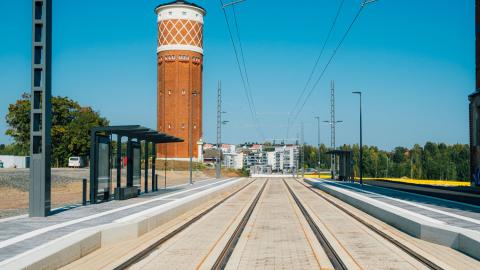 Ratikkapysäkki Tehdas Hiedanrannassa, taustalla vanha vesitorni.