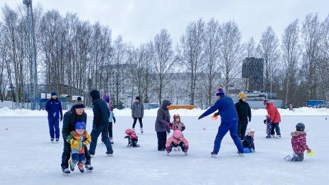 Lapsiperheitä luistelukurssilla Sorsapuiston tekojäällä.