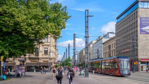 Kuva Hämeenkadulta, jossa näkyy jalankulkijoita ja ratikka kesäpäivänä
