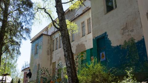 Entinen Pyynikin sairaala on huonokuntoisen näköinen rakennus, jonka ulkoseinissä on graffiteja.