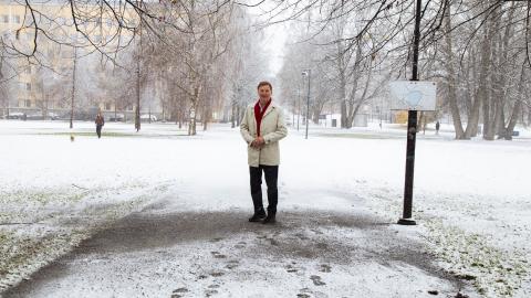 Henkilö seisoo lumisessa maisemassa.