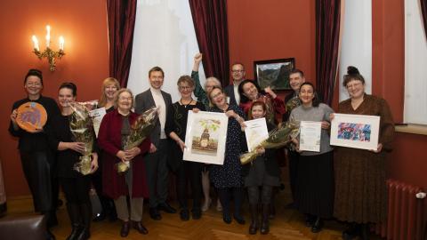 Tampereen kulttuuri- ja vapaa-aikalautakunnan kaksitoista palkittua sekä apulaispormestari Matti Helimo ja sivistyspalvelujen johtaja Lauri Savisaari seisovat Raatihuoneella.