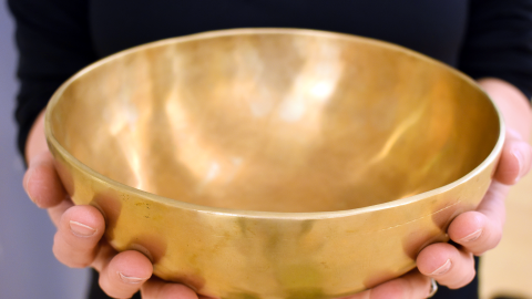 Kädet pitelevät tyhjää äänimaljaa.