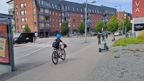 Lapsia pyöräilemässä kaupunkiympäristössä.