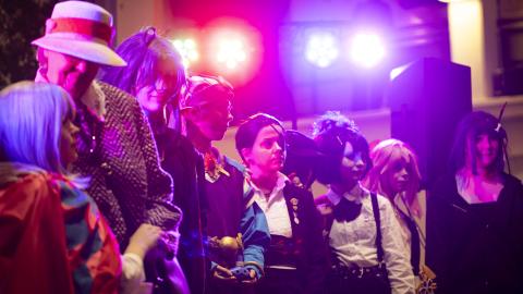 Ihmisiä rivissä erilaisissa naamiaisasuissa.