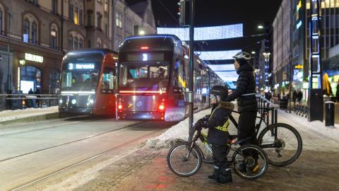 Kaksi raitiovaunua ja kaksi pyöräilijää talvisella Hämeenkadulla.