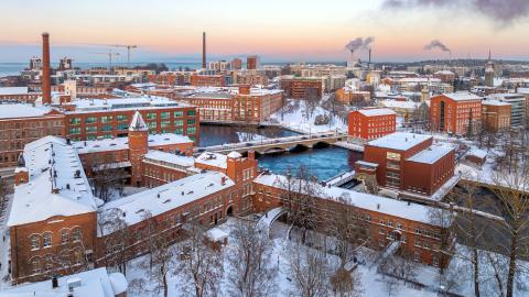 Talvinen näkymä ilmastakäsin Tampereen keskustasta, jossa punatiilisiä vanhoja rakennuksia etualalla.