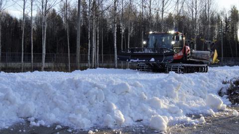 Latukone levittää lunta ladulle 