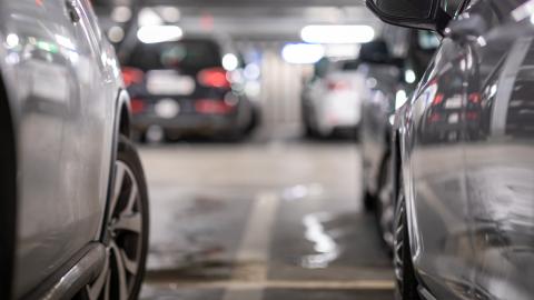 Henkilöautoja parkkiruuduissaan parkkihallissa.