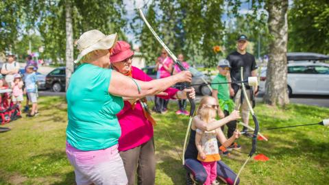 Ikäihminen opettelee jousiammuntaa