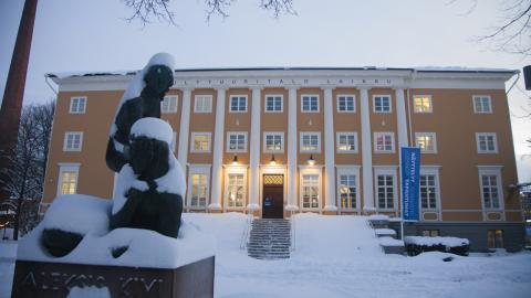 Suuri keltainen rakennus talvisessa maisemassa.