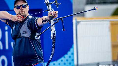 Jousiampuja tähtäämässä jousipyssyllä maaliin 