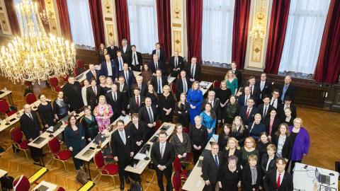 The councillors stand in the banquet hall and look up into the camera.