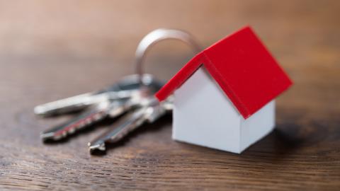 The keyring on the table and the keyring is a small red-roofed cottage.