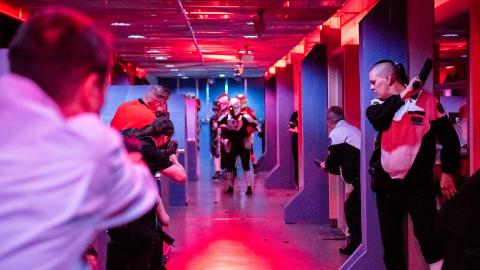 Punaiseksi valaistussa käytävässä ihmisiä pelaamassa liveroolipeliä. 