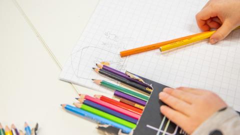 Lapsi käsittelee värikyniä.