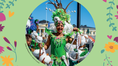 The samba player is wearing a green carnival costume and smiling as he dances.