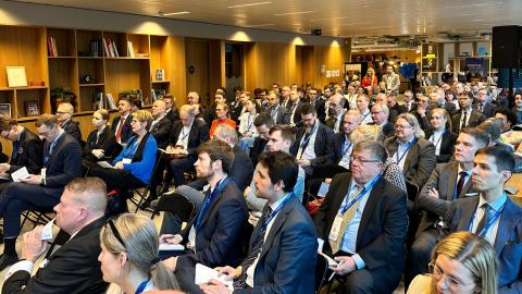 Yleisöä katsomossa kymmenittäin kuuntelemassa.