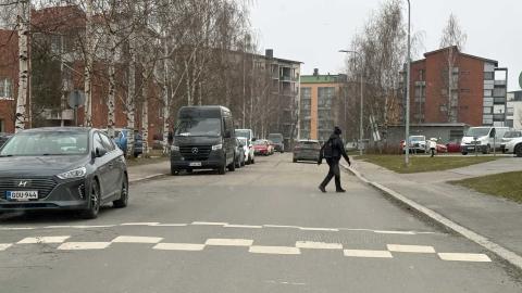 Katu ja kerrostaloja, jalankulkija, autoliikenteen hidaste.