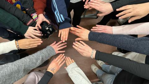 Paljon käsiä koottuna yhteen yhteistyön merkiksi.