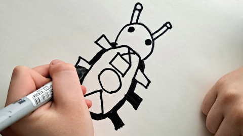 The child holds a black marker and draws a beetle-like bug on white paper.