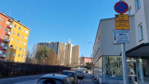 Autoja parkissa Kalevassa. Etualalla liikennemerkki, jossa siirtokehotustaulu.