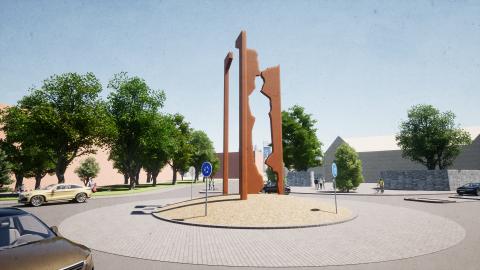 Neljä muotoiltua teräspylvästä liikenneympyrän keskellä.