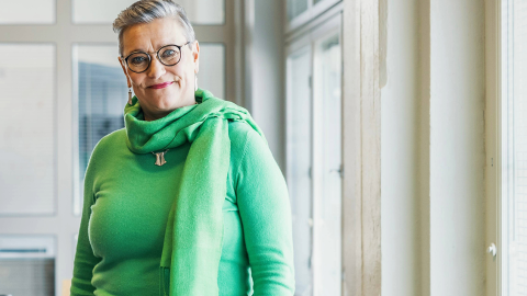 Henkilö seisoo ikkunan edessä ja katsoo kameraan.