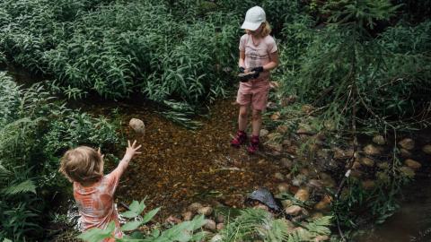 Kaksi lasta puronkunnostustalkoissa. 