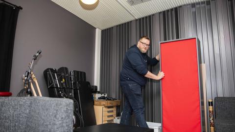 Teemu Haapakoski katsoo kameraan ja siirtää bassoansaa Monitoimitalo 13:n studiossa.