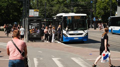 Ihmisvilinää Koskipuiston bussipysäkillä.