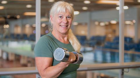 Iloinen nainen käsipaino kädessä 