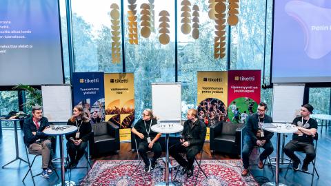 Panelistit keskustelemassa tapahtuman lavalla.