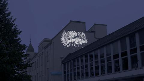 Moomin illustration projected onto the wall of a building.