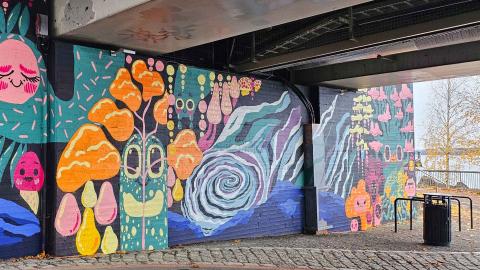 Värikäs taideseinä sillan alla.