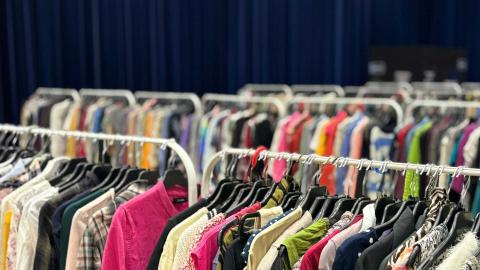 Vaatteita roikkumassa vaatetelineillä.