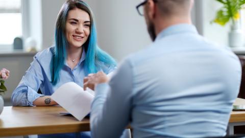 Sinihiuksinen nuori työpaikkahaastattelussa