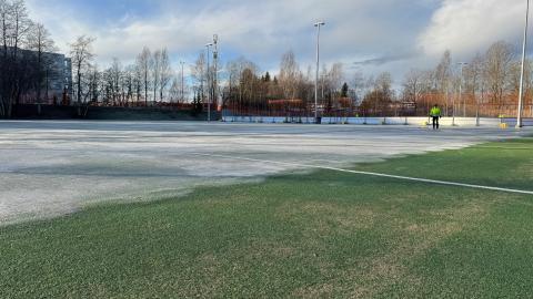 Kenttäalue, jossa osittain jäätä, osittain nurmea 