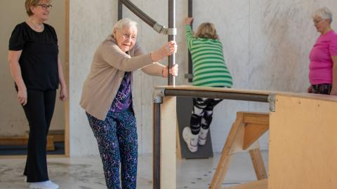 Neljä seniori-ikäistä naista liikuntasalissa.