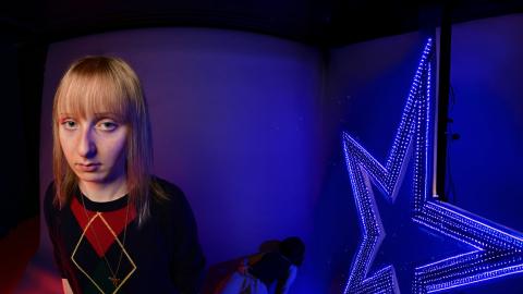 Tyttö seisoo katsoen kameraa