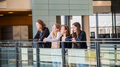 Neljän opiskelijan ryhmä Sammon lukion avarassa aulassa katsomassa kaukaisuuteen.