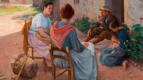 Perhe istuu vanhan talon edustalla varjossa auringolta.