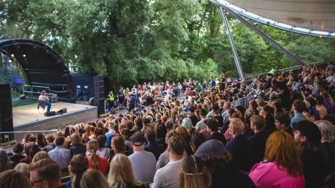 Kesäteatterilavalla festivaaliesitys sekä yleisöä.