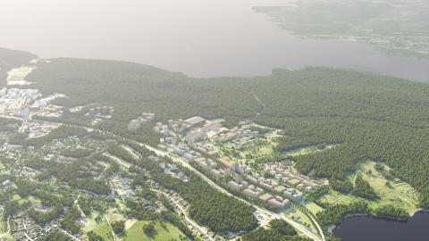 Laaja ilmakuva, jossa takana järvi ja uusi asuinalue keskellä.