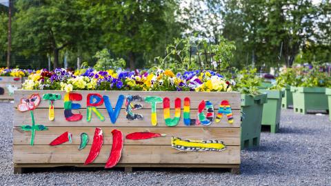 A planter box with a colorful welcome message on the side.