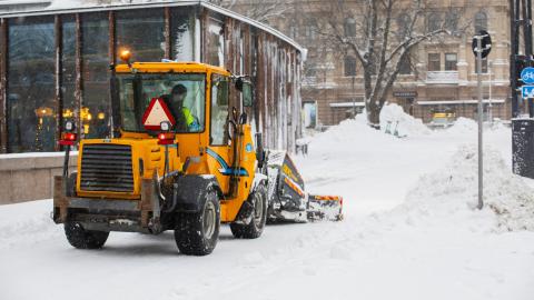 Auraustraktori lumitöissä keskustassa takaapäin kuvattuna.