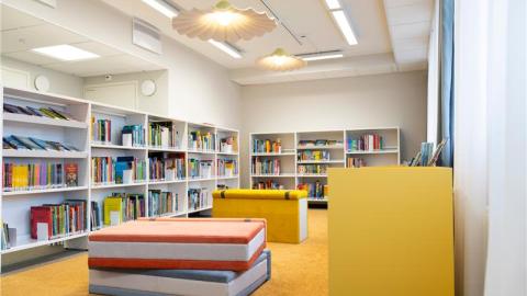 Yleiskuva Nekalan kirjastosta. Isoja kirja-aiheisia kalusteita ja kirjahyllyjä.